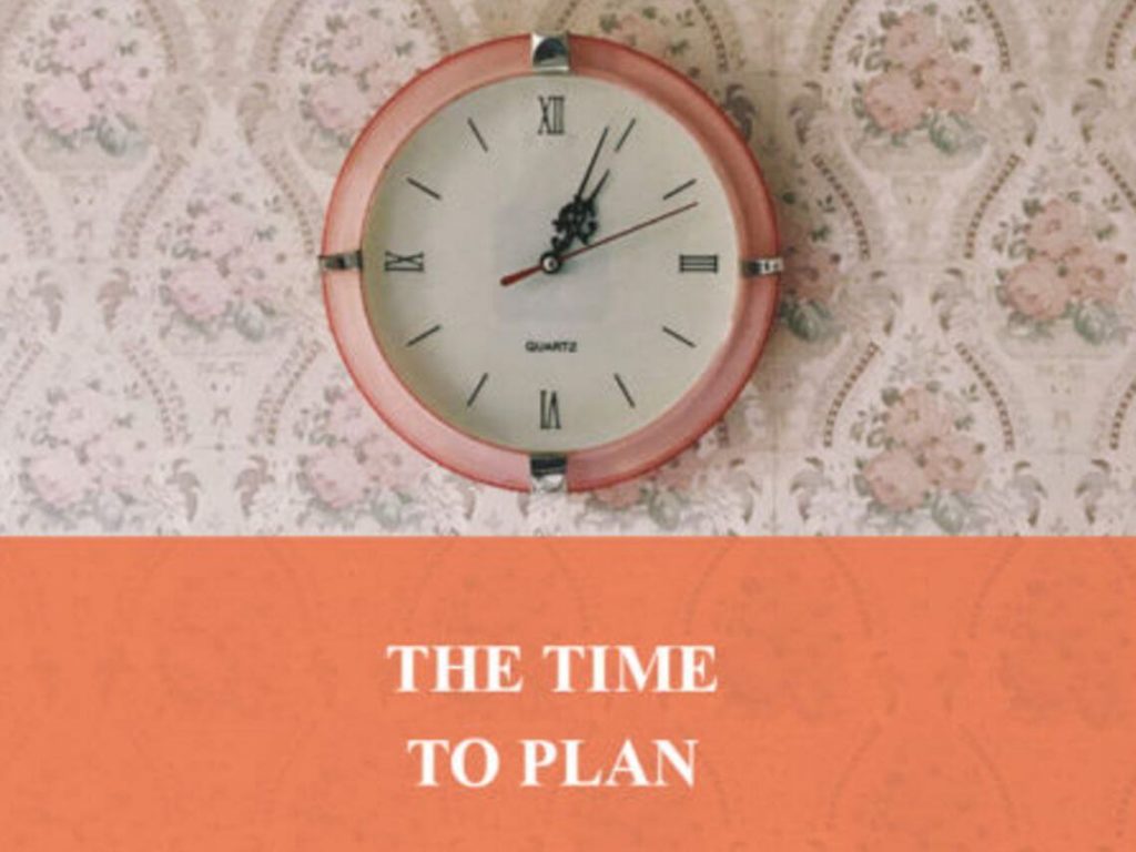A peach colored clock hanging on a wall. planning