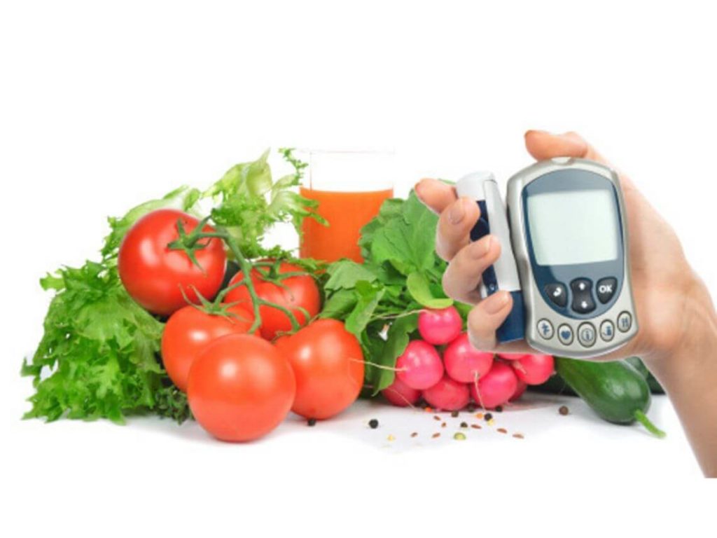 A person holding up their blood glucose monitor ready to eat their diabetes friendly food