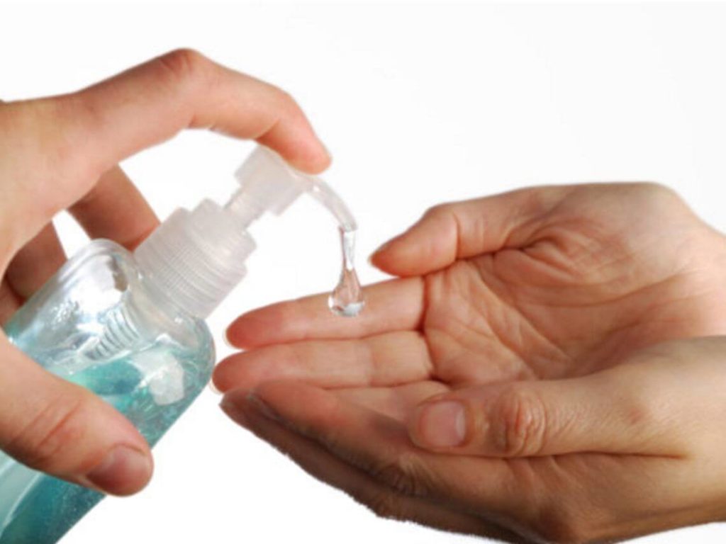 A person is putting hand sanitizer in someone's hand