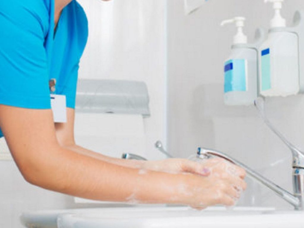 A healthcare worker is washing his hands promoting illness prevention