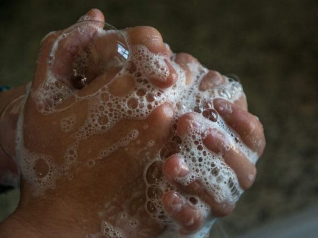 A person is washing their hands with lots of soap to prevent the spread illness