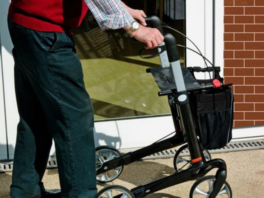 An elderly gentleman is using his scooter to get around