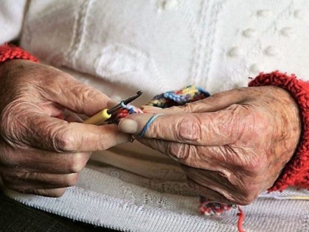 Elderly woman knitting to deal with memory loss