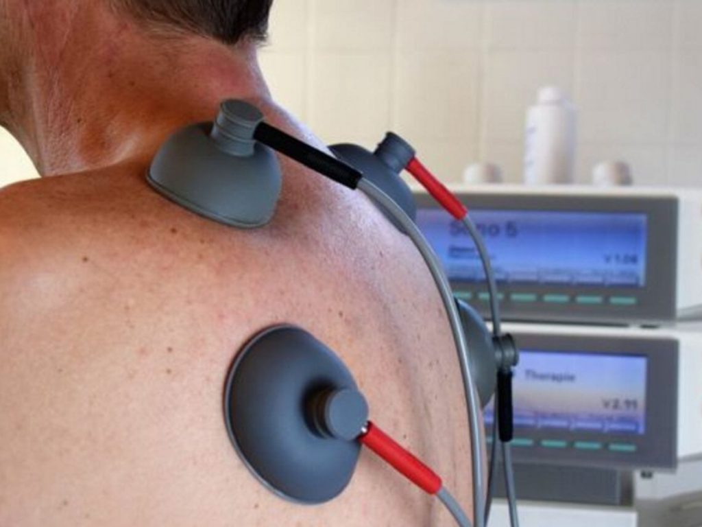 A man is getting tests done with wires suctioned to his back