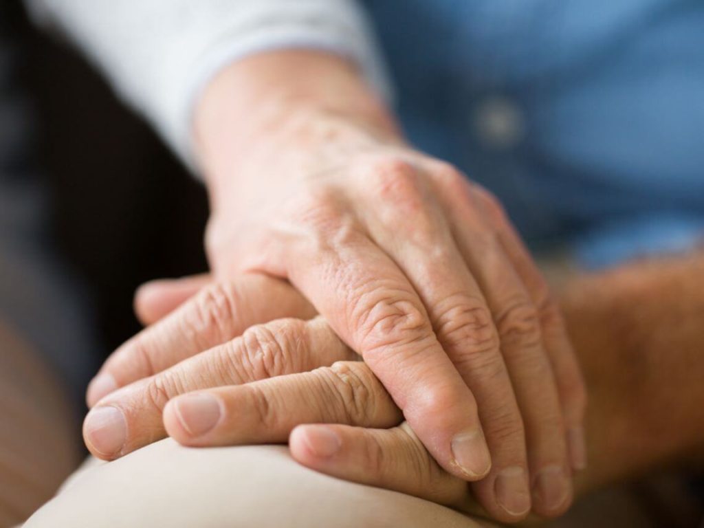 An elderly couple holding hands arthritis