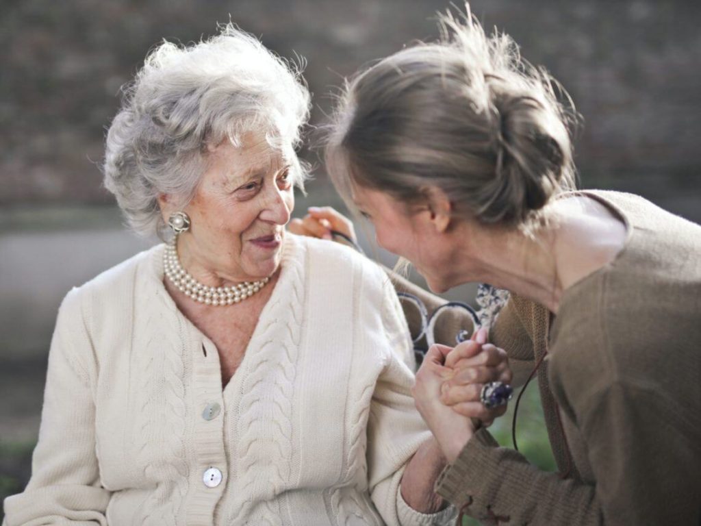 two elderly women lovingly talking to each other