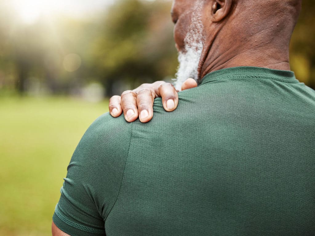 man holding shoulder in need of physical therapy