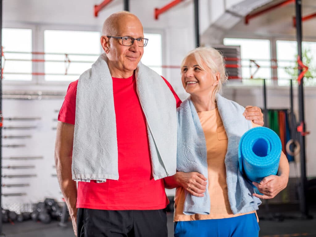 senior couple staying active at fitness club