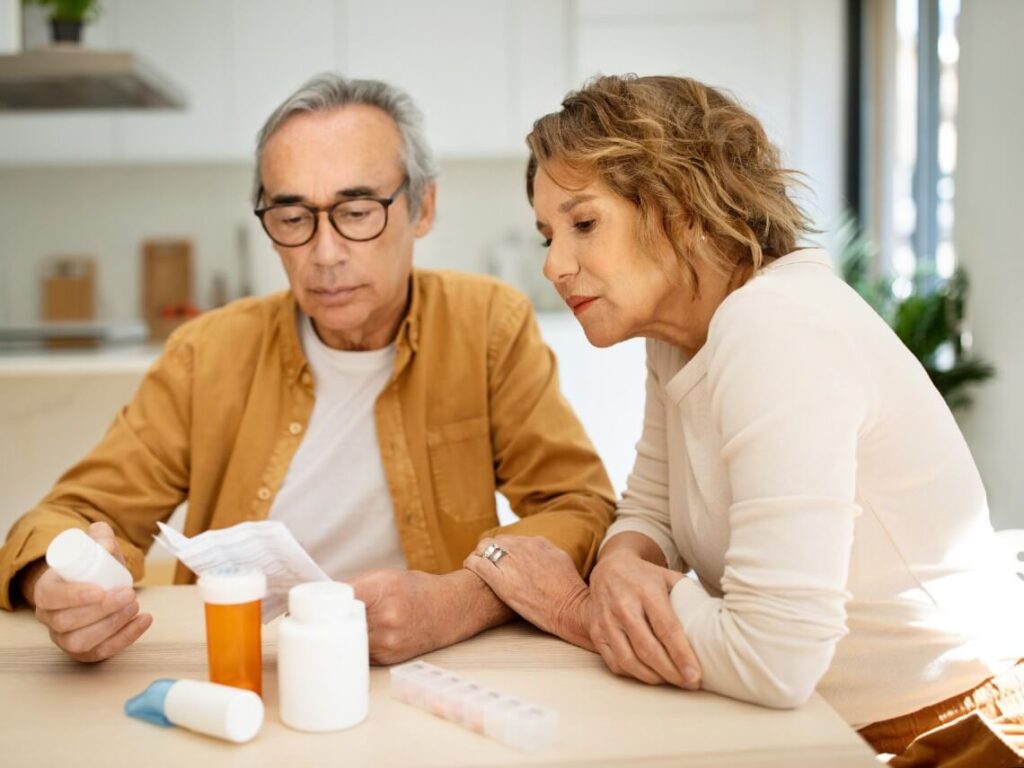 Senior couple looking at medications on table