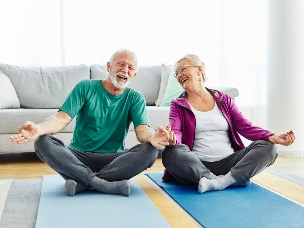 Senior couple doing yoga on mats