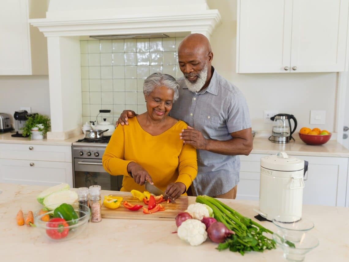 Senior couple preparing meal in kitchen