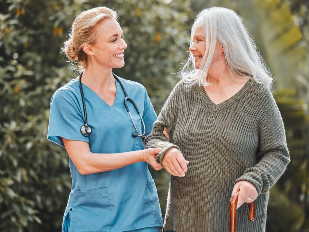 Senior woman walking with female nurse